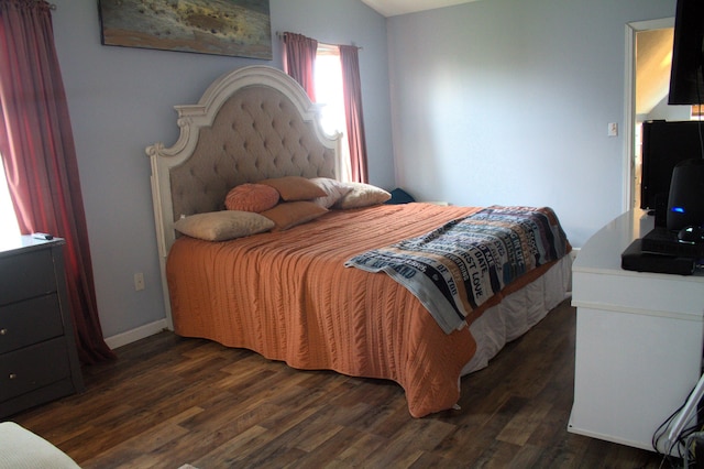 bedroom with dark hardwood / wood-style floors