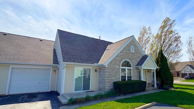 7837 Farmsbury Dr, Reynoldsburg, OH 43068 - view of front facade featuring a garage, a front yard, stone siding, roof with shingles, and driveway