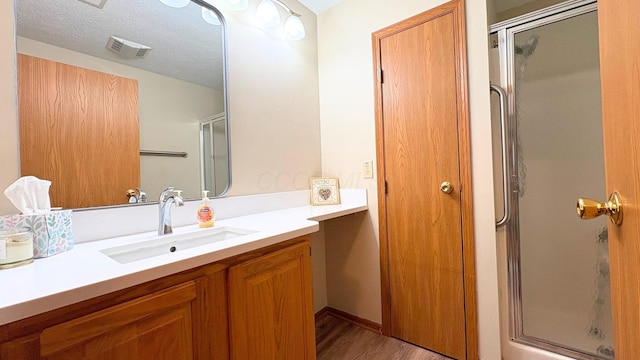 7837 Farmsbury Dr, Reynoldsburg, OH 43068 - full bathroom with vanity, a stall shower, wood finished floors, and visible vents
