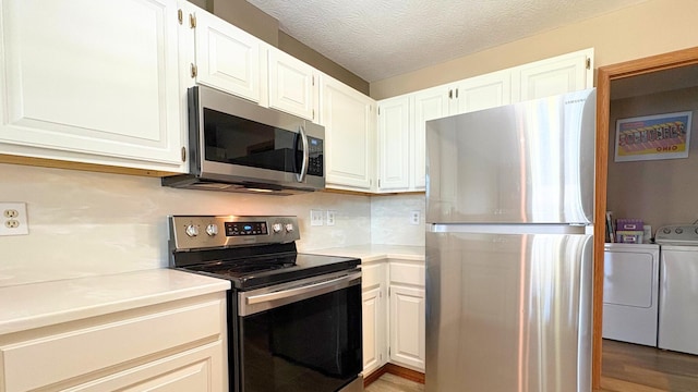 7837 Farmsbury Dr, Reynoldsburg, OH 43068 - kitchen with washer and dryer, light countertops, white cabinets, light wood finished floors, and stainless steel appliances