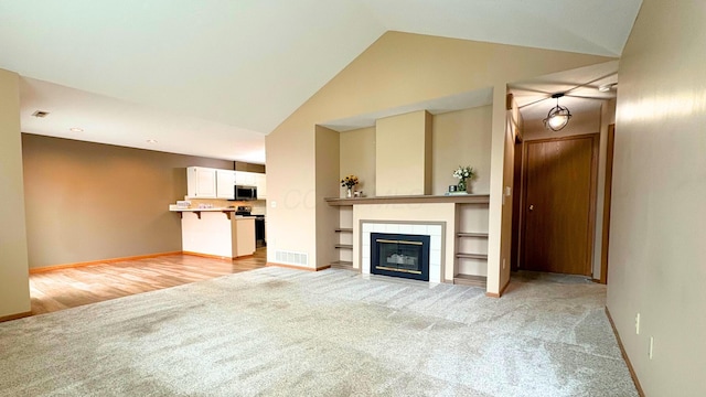 7837 Farmsbury Dr, Reynoldsburg, OH 43068 - unfurnished living room featuring visible vents, a fireplace, light carpet, baseboards, and high vaulted ceiling