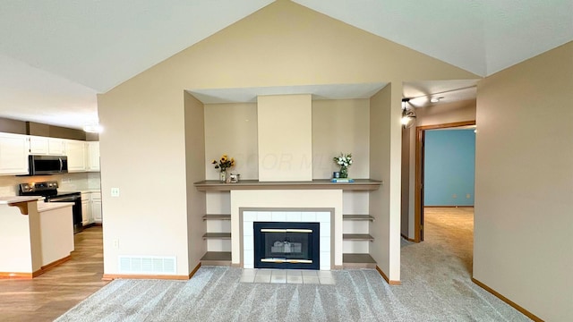 7837 Farmsbury Dr, Reynoldsburg, OH 43068 - unfurnished living room with light carpet, visible vents, baseboards, a tile fireplace, and vaulted ceiling