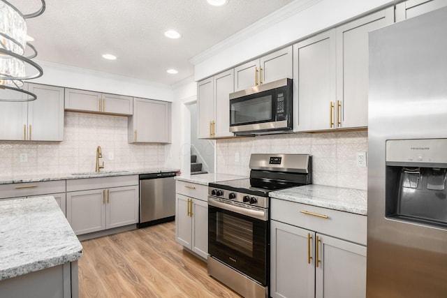 kitchen with gray cabinetry, sink, appliances with stainless steel finishes, and light hardwood / wood-style flooring