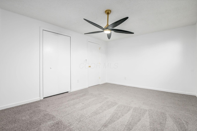 unfurnished bedroom with ceiling fan, carpet floors, and a textured ceiling