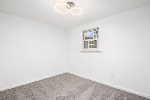 carpeted spare room with a textured ceiling