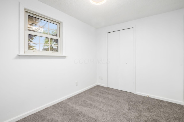 spare room featuring carpet and a textured ceiling