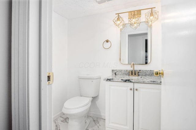 bathroom featuring a textured ceiling, vanity, and toilet