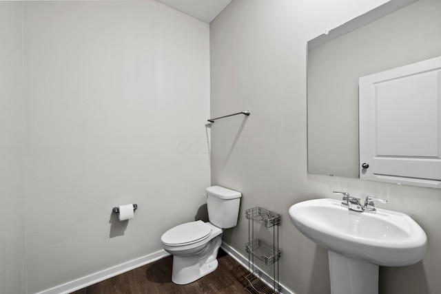 bathroom with sink, hardwood / wood-style floors, and toilet