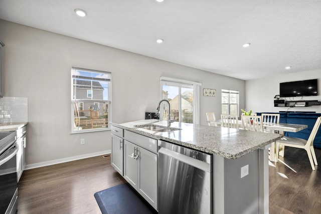 kitchen featuring gray cabinetry, sink, stainless steel appliances, dark hardwood / wood-style flooring, and a kitchen island with sink