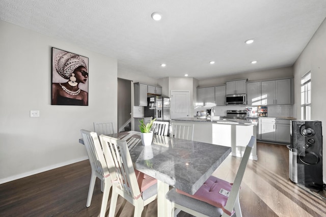 dining space with a textured ceiling and dark wood-type flooring