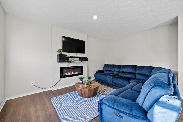 living room with dark hardwood / wood-style flooring and a textured ceiling