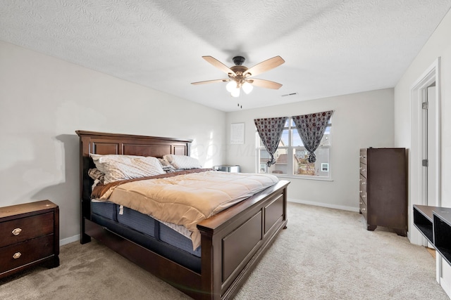 carpeted bedroom featuring ceiling fan and a textured ceiling