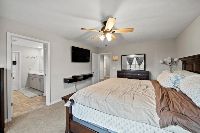 bedroom with light carpet, a textured ceiling, ensuite bath, and ceiling fan