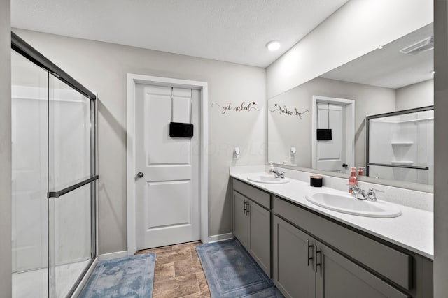 bathroom featuring a textured ceiling, vanity, and an enclosed shower