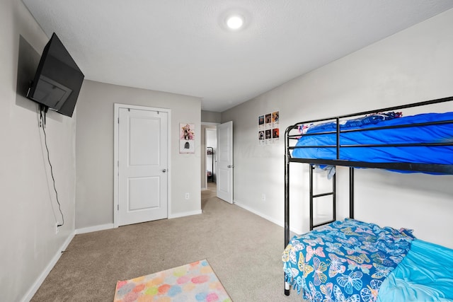 bedroom featuring light colored carpet and a textured ceiling