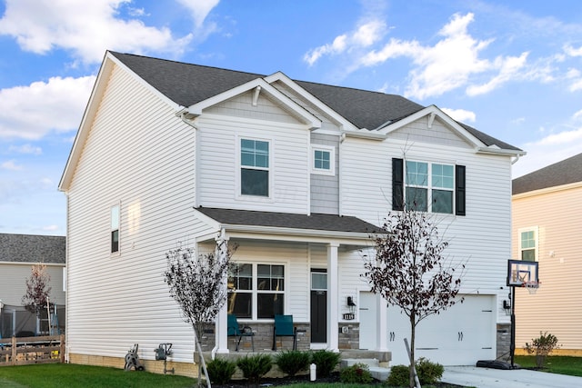 view of front of house featuring a front yard, a porch, and a garage