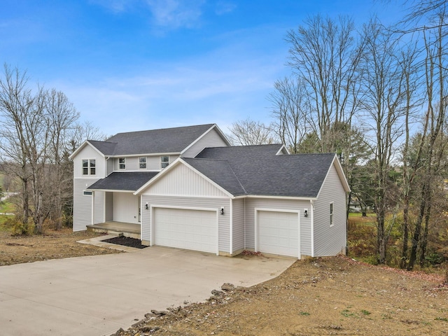 traditional-style house featuring a garage, a shingled roof, and concrete driveway