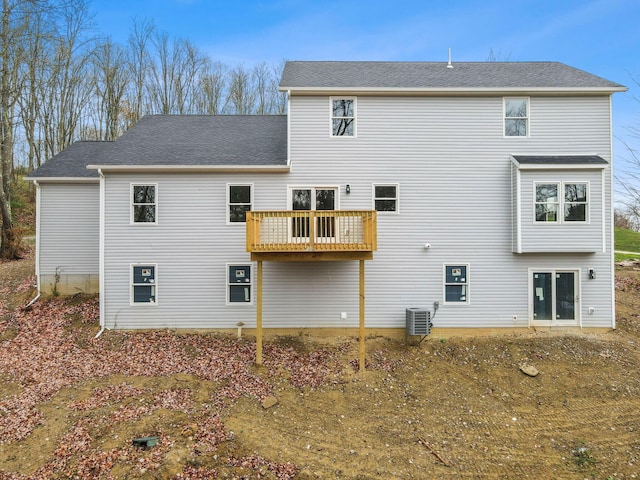 rear view of property featuring a shingled roof and central AC unit