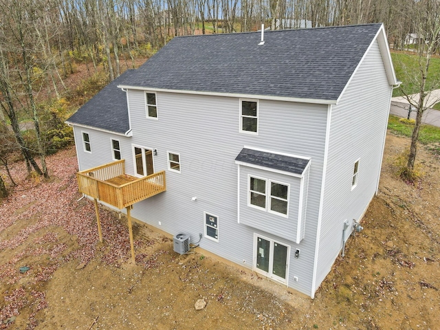 rear view of property featuring central AC, roof with shingles, and a wooden deck