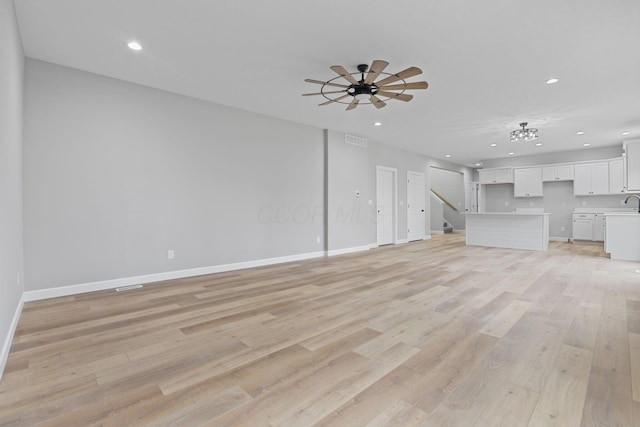 unfurnished living room featuring recessed lighting, visible vents, a ceiling fan, light wood-type flooring, and baseboards