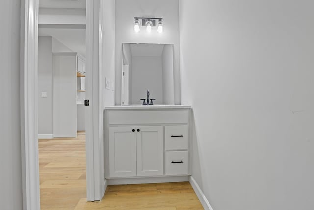 bathroom with vanity, baseboards, and wood finished floors