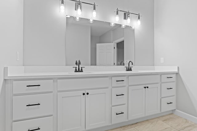 bathroom featuring a sink, baseboards, and double vanity