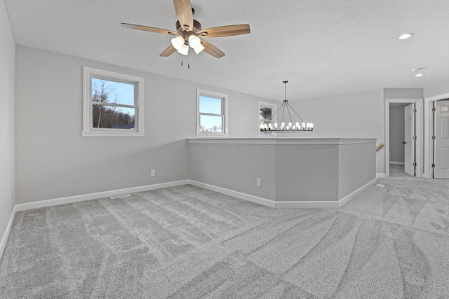 unfurnished room featuring a textured ceiling, carpet flooring, and baseboards