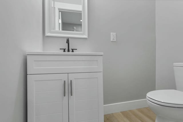 bathroom featuring hardwood / wood-style floors, vanity, and toilet