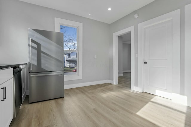 kitchen featuring white cabinets, stainless steel appliances, and light wood-type flooring