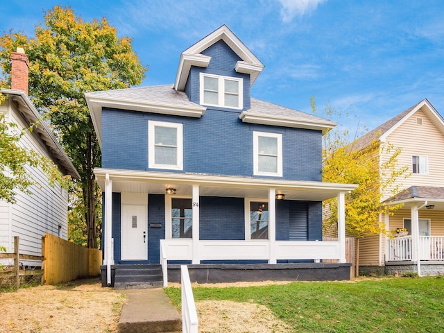 view of front of property featuring covered porch and a front yard