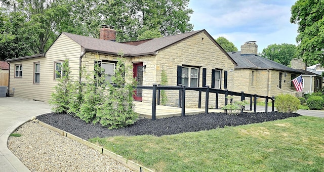 view of front of property featuring central AC and a front yard