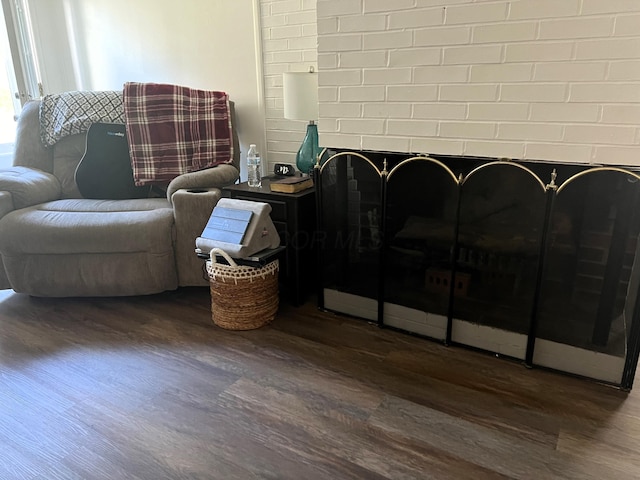 interior space featuring dark hardwood / wood-style flooring and brick wall