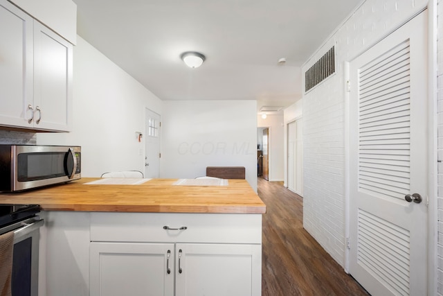 kitchen featuring dark hardwood / wood-style floors, white cabinetry, and butcher block countertops