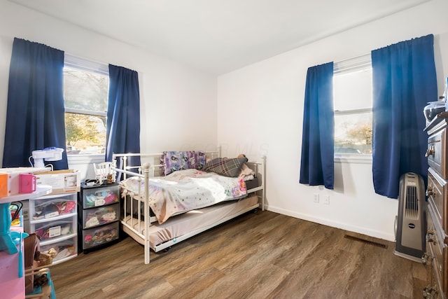 bedroom with wood-type flooring and heating unit