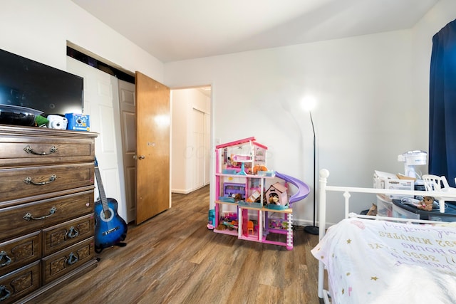 bedroom featuring a barn door, dark hardwood / wood-style flooring, and a closet