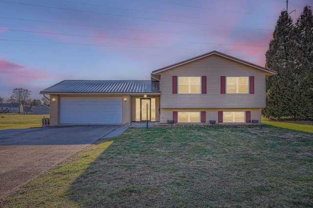 tri-level home featuring a lawn and a garage