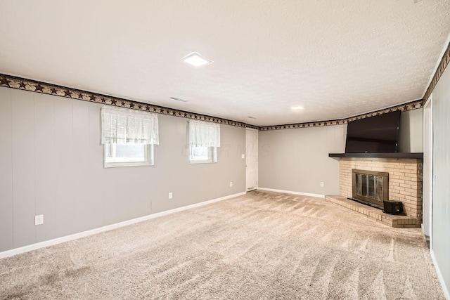 basement with carpet, a textured ceiling, and a brick fireplace