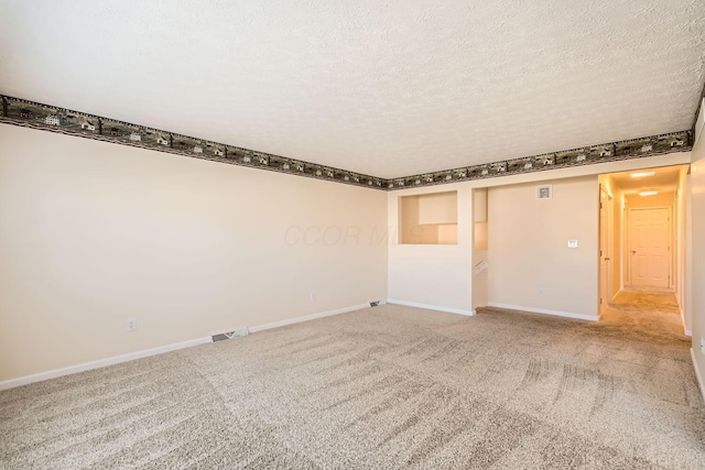 carpeted empty room with a textured ceiling