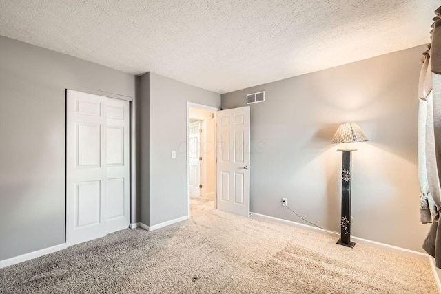 unfurnished bedroom with a closet, carpet, and a textured ceiling