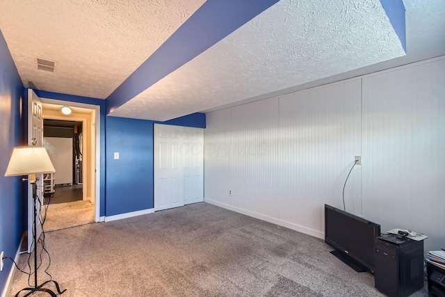 interior space featuring carpet floors and a textured ceiling