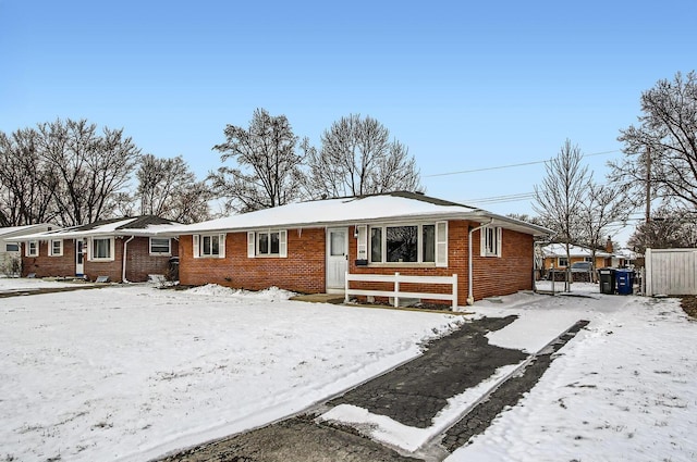 single story home with entry steps, fence, and brick siding