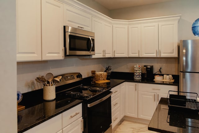 317 Johnson St, Columbus, OH 43203 - kitchen featuring appliances with stainless steel finishes, white cabinets, light marble finish flooring, tasteful backsplash, and dark stone countertops