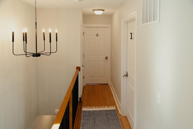 corridor featuring hardwood / wood-style flooring and a chandelier