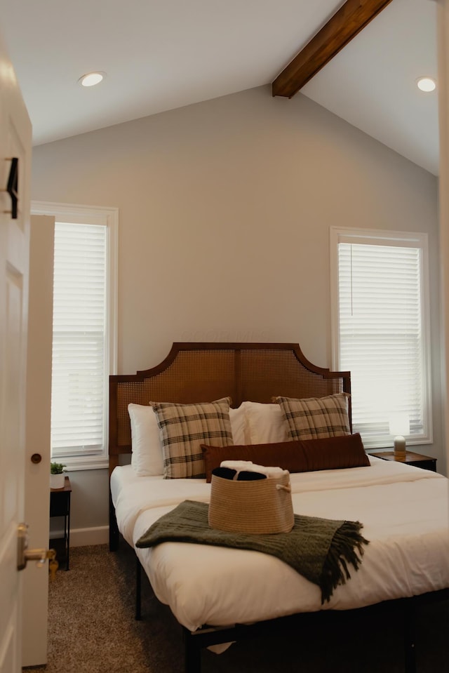 bedroom featuring vaulted ceiling with beams, dark carpet, and multiple windows