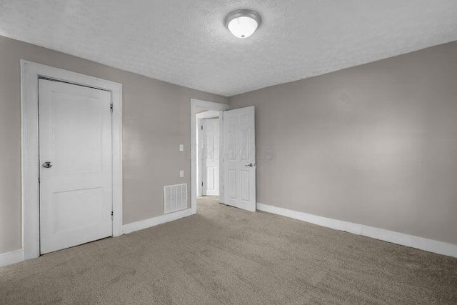 1371 E 23rd Ave, Columbus, OH 43211 - unfurnished bedroom featuring a textured ceiling, carpet flooring, and baseboards