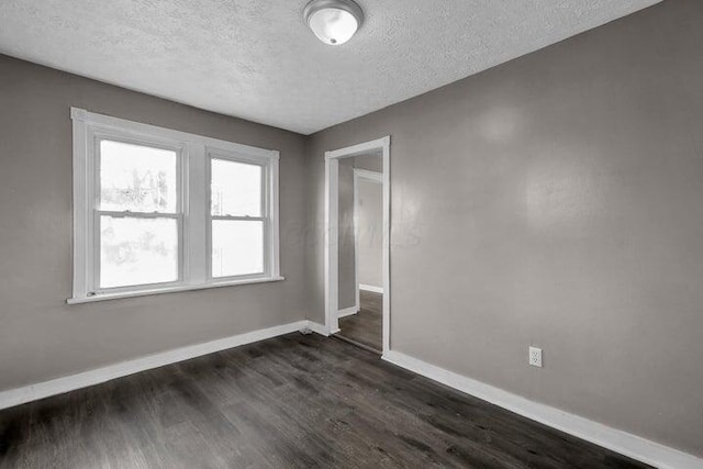 1371 E 23rd Ave, Columbus, OH 43211 - empty room featuring baseboards, a textured ceiling, and dark wood-style flooring