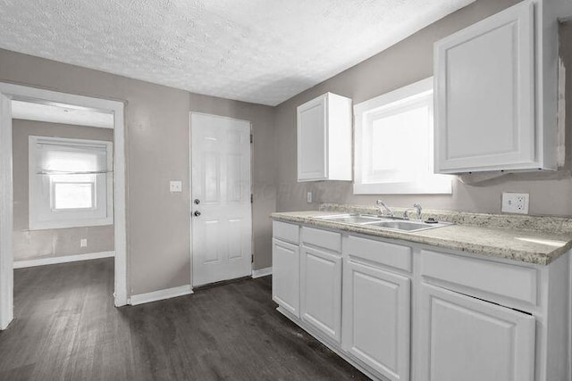 1371 E 23rd Ave, Columbus, OH 43211 - kitchen featuring a sink, dark wood-type flooring, baseboards, white cabinetry, and light countertops