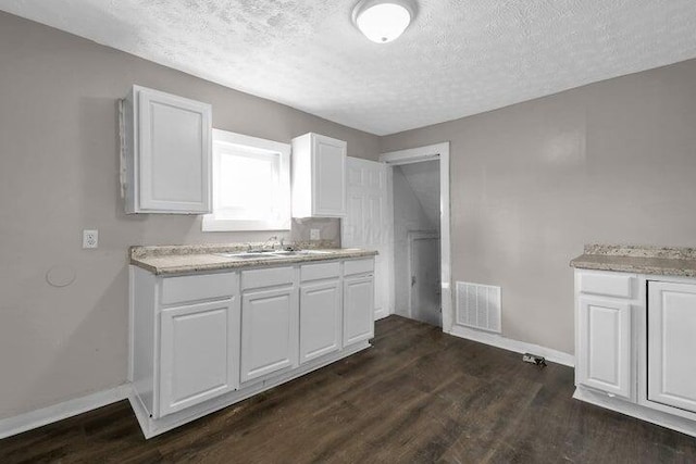 1371 E 23rd Ave, Columbus, OH 43211 - kitchen featuring a sink, a textured ceiling, white cabinets, baseboards, and dark wood-type flooring