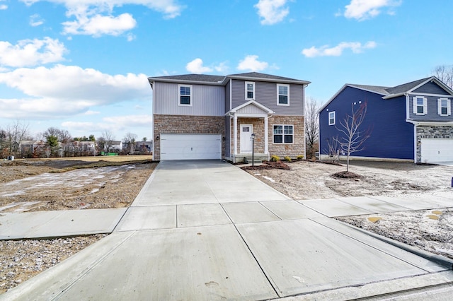 traditional-style house featuring an attached garage, stone siding, and driveway