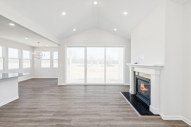 800 Heritage Blvd, Delaware, OH 43015 - unfurnished living room with a fireplace, a chandelier, baseboards, wood finished floors, and vaulted ceiling